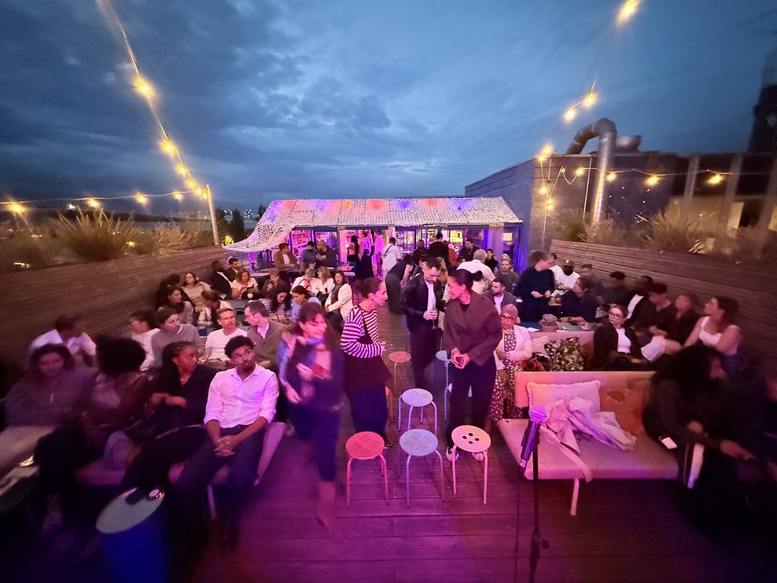 Les spectateurs s’installent sous les guirlandes lumineuses du Rooftop 105 avant la soirée Cosy Comedy du 30 septembre 2026
